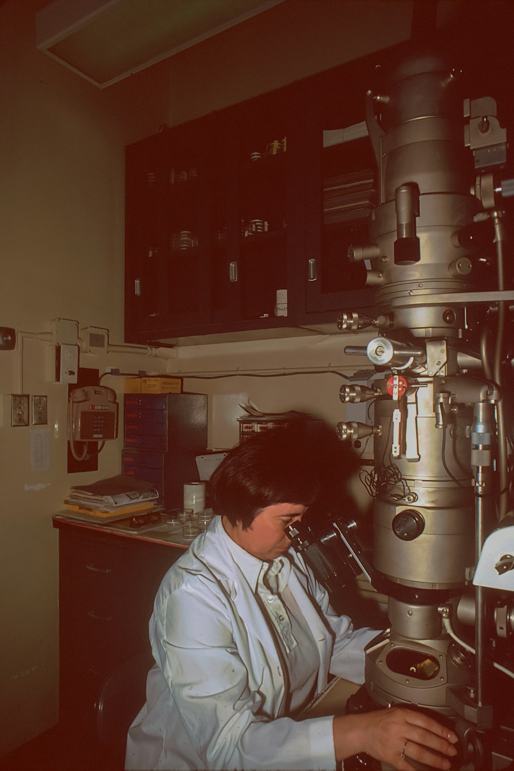 Scientist examining a specimen using an electron microscope